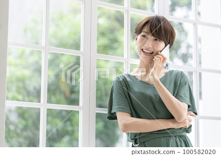 A middle-aged woman talking on her smartphone A middle-aged woman talking on her smartphone 100582020