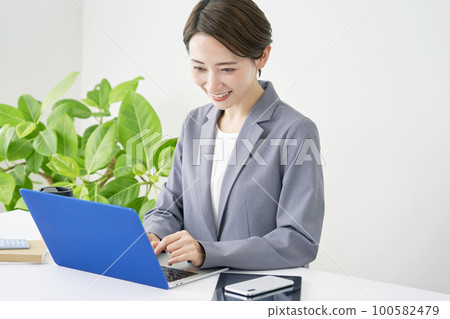 在筆記本電腦上做案頭工作的女商人 100582479