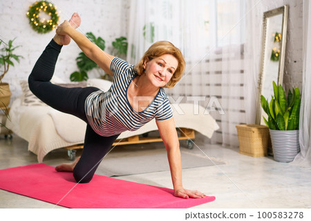 Mature woman doing sports on mat at home Mature woman doing sports on mat at home 100583278