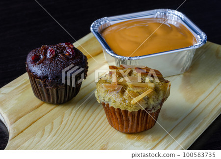 Chocolate muffin, banana cupcake and milk tea fudge cake on wooden tray. Chocolate muffin, banana cupcake and milk tea fudge cake on wooden tray. 100583735