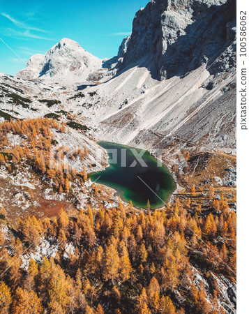 Vertical photo of fantastic mountain lake in Triglav national park with scree slopes under mountain tops surrounding the lake Vertical photo of fantastic mountain lake in Triglav national park with scree slopes under mountain tops surrounding the lake 100586062