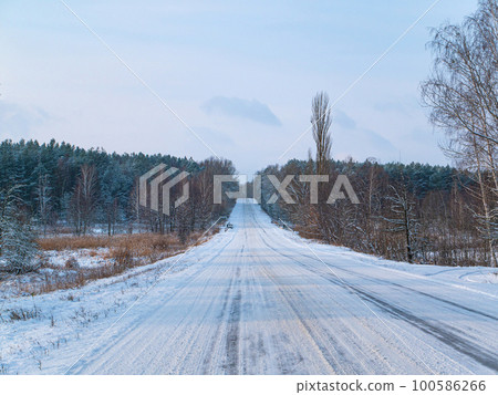 Winter road in the snow leaving the forest horizon. Winter road in the snow leaving the forest horizon. 100586266