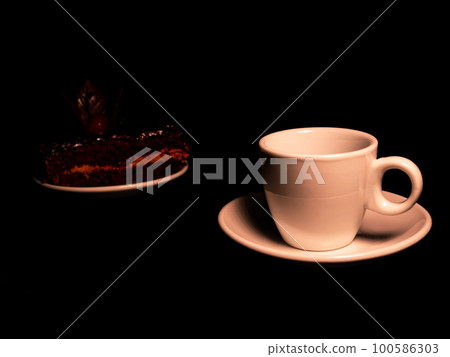 Chocolate cake with cherries and a cup of coffee on a black background. 100586303