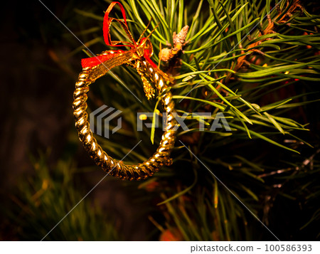 Decorative ring in golden color on the Christmas tree. Decorative ring in golden color on the Christmas tree. 100586393