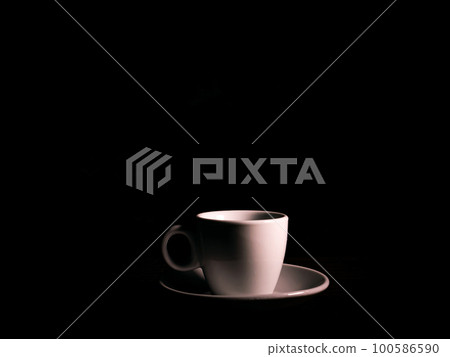 White ceramic coffee cup with saucer on a black background. White ceramic coffee cup with saucer on a black background. 100586590
