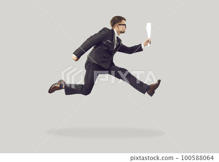 Funny young office worker in suit holding business documents and hurrying to work Funny young office worker in suit holding business documents and hurrying to work 100588064