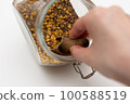 close up of a hand holding a spoon of seeds 100588519