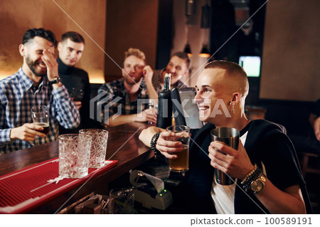 Expressive people watching soccer. Group of people together indoors in the pub have fun at weekend time Expressive people watching soccer. Group of people together indoors in the pub have fun at weekend time 100589191