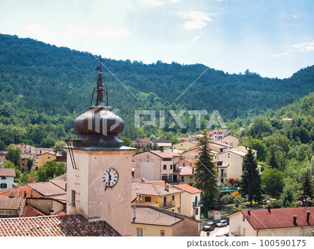 a clock tower in a town in the mountains of Italy. a clock tower in a town in the mountains of Italy. 100590175