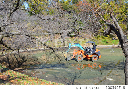 Heavy equipment lowered into a drained pond 100590748