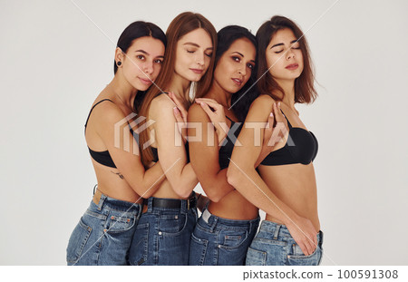 Leaning on each other. Four young women in lingerie together indoors. White background Leaning on each other. Four young women in lingerie together indoors. White background 100591308