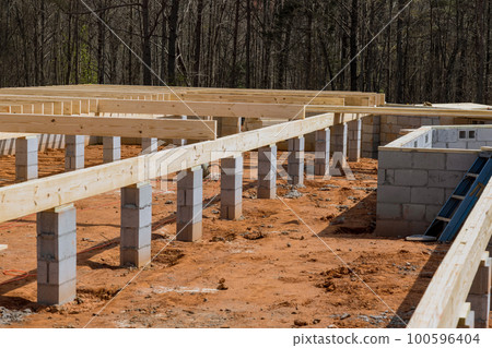 Installation work wood floor joist trusses layout on concrete block foundation new custom home 100596404