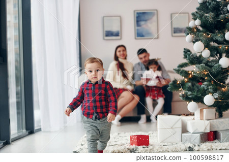Beautiful family celebrates New year and christmas indoors at home 100598817