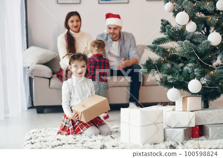 Beautiful family celebrates New year and christmas indoors at home Beautiful family celebrates New year and christmas indoors at home 100598824