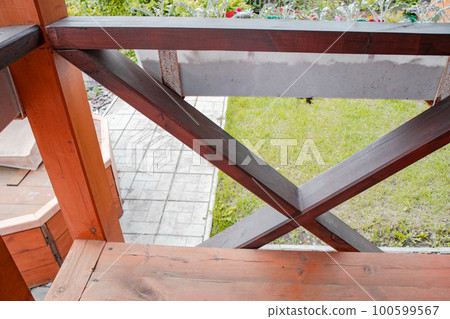 Close-up of the fence on the porch of the terrace, view from the inside. blurred summer garden background Close-up of the fence on the porch of the terrace, view from the inside. blurred summer garden background 100599567