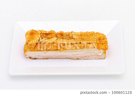 top view of a piece of Chinese roasted pork belly on a white dish on isolated white background. top view of a piece of Chinese roasted pork belly on a white dish on isolated white background. 100601128