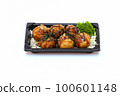 Takoyaki, mayonnaise, soy sauce, sprinkled with seaweed in a black plate on a white background. 100601148