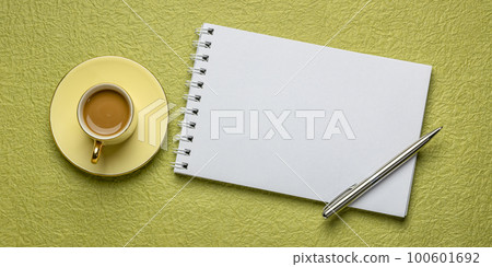 blank spiral sketchbook against textured paper with a cup of coffee, desktop flat lay blank spiral sketchbook against textured paper with a cup of coffee, desktop flat lay 100601692