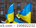Flag with yellow and blue striped colors of Ukraine waving in the wind with a blue sky and sun. 100602232