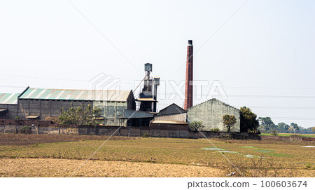 Industrial Factory Building landscape against clear sky background and agriculture field in the foreground. Industrial Factory Building landscape against clear sky background and agriculture field in the foreground. 100603674