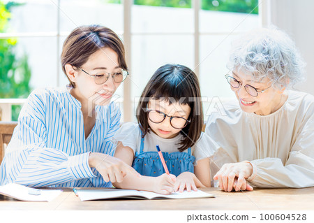 Girl studying and family watching Girl studying and family watching 100604528