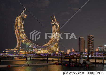 Katara Hospitality Tower, or Lusail Katara Hotel North Tower in Lusail, Qatar at dusk showing the unique architecture of the illuminated tower Katara Hospitality Tower, or Lusail Katara Hotel North Tower in Lusail, Qatar at dusk showing the unique architecture of the illuminated tower 100604975
