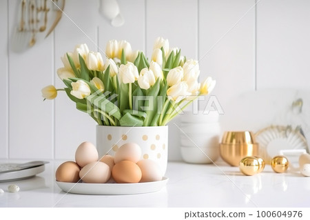 Easter table setting with tulips, Easter bunnies, and eggs with golden patterns in the white Scandinavian-style kitchen background. Beautiful minimalist design for greeting card Easter table setting with tulips, Easter bunnies, and eggs with golden patterns in the white Scandinavian-style kitchen background. Beautiful minimalist design for greeting card 100604976