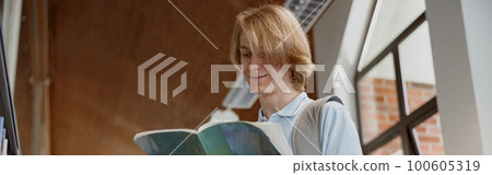 Student reads study notes while standing in the university library. Education concept Student reads study notes while standing in the university library. Education concept 100605319