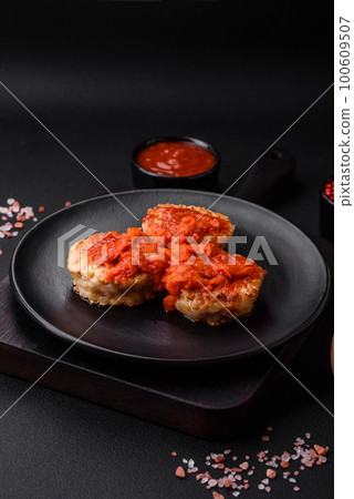 Delicious fresh cutlets or meatballs with spices, herbs and tomato sauce 100609507