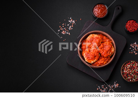 Delicious fresh cutlets or meatballs with spices, herbs and tomato sauce Delicious fresh cutlets or meatballs with spices, herbs and tomato sauce 100609510