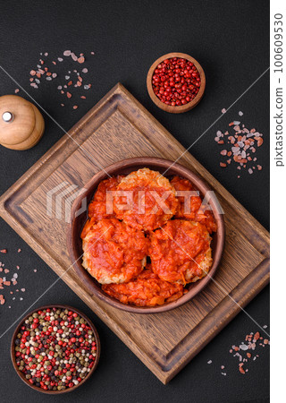 Delicious fresh cutlets or meatballs with spices, herbs and tomato sauce Delicious fresh cutlets or meatballs with spices, herbs and tomato sauce 100609530