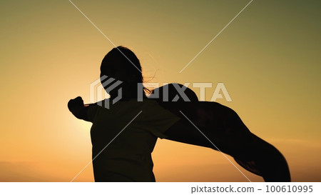 girl superhero sunset glare. game teenager red raincoat top mountain. glare sun sky. brave superhero meets day dawn. children dream.girl red raincoat wind. superhero costume. child pray wind sun. 100610995
