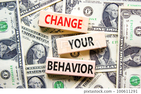 Motivation and Change your behavior symbol. Concept words Change your behavior on wooden block on a beautiful background from dollar bills. Business change your behavior concept. Copy space. 100611291