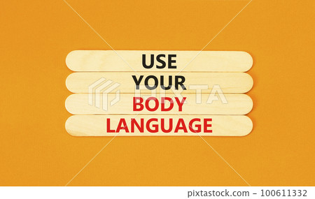 Use your body language symbol. Concept words Use your body language on wooden stick. Beautiful orange table orange background. Motivational business use your body language concept. Copy space. 100611332