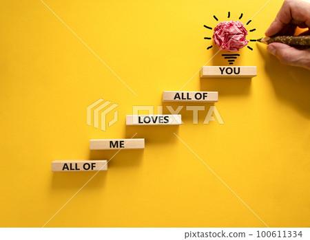 All of me loves all of you symbol. Wooden blocks with words All of me loves all of you on beautiful yellow background, copy space. Businessman hand, light bulb icon. Lifestyle, love concept. 100611334