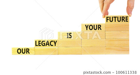 Legacy and future symbol. Concept words Our legacy is your future on wooden blocks. Beautiful white table white background. Businessman hand. Business legacy and future concept. Copy space. Legacy and future symbol. Concept words Our legacy is your future on wooden blocks. Beautiful white table white background. Businessman hand. Business legacy and future concept. Copy space. 100611338