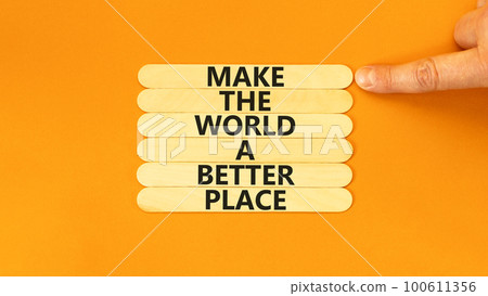 Make a better world symbol. Concept words Make the world a better place on wooden stick. Beautiful orange table orange background. Businessman hand. Business make a better world concept. Copy space. 100611356