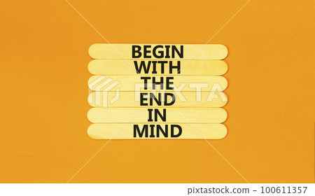 Begin in end of mind symbol. Concept words Begin with the end in mind on wooden stick. Beautiful orange table orange background. Business begin in end of mind concept. Copy space. 100611357