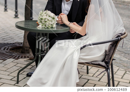 a man and a woman hold hands at the wedding of newlyweds 100612489