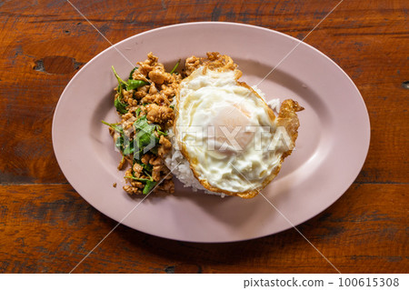 Overhead view of Prad Ka Pao, popular Thai steet food made up of fried minced pork with basil and fried egg with rice Overhead view of Prad Ka Pao, popular Thai steet food made up of fried minced pork with basil and fried egg with rice 100615308