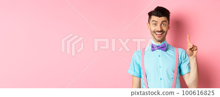 Cheerful caucasian man pitching an idea, raising finger in eureka gesture and smiling, suggesting solution, standing on pink background Cheerful caucasian man pitching an idea, raising finger in eureka gesture and smiling, suggesting solution, standing on pink background 100616825