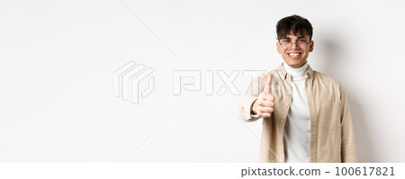 Image of happy young man showing thumb up and smiling satisfied, praise good job, say well done and look pleased, standing on white background Image of happy young man showing thumb up and smiling satisfied, praise good job, say well done and look pleased, standing on white background 100617821