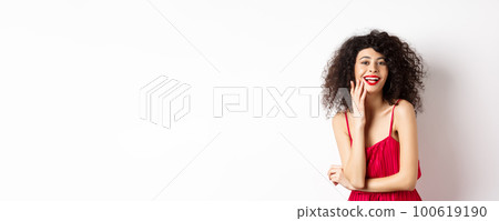 Attractive woman in party dress, laughing and having fun, smiling happy at camera, wearing makeup red lipstick, standing on white background Attractive woman in party dress, laughing and having fun, smiling happy at camera, wearing makeup red lipstick, standing on white background 100619190