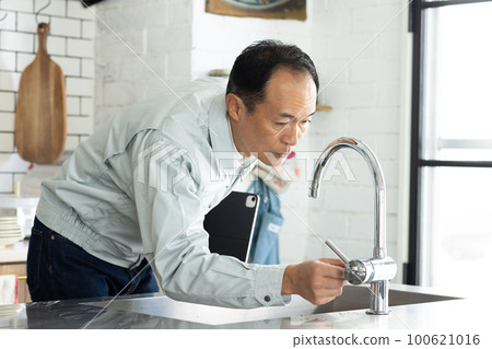 一個穿著工作服的男人站在廚房裡 100621016