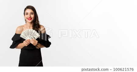 Beauty and shopping concept. Fashionable woman with red lips, showing dollars and smiling, standing over white background with money Beauty and shopping concept. Fashionable woman with red lips, showing dollars and smiling, standing over white background with money 100621576