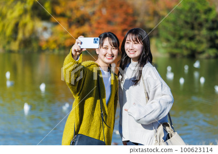 年輕女子在公園的水邊自拍 100623114