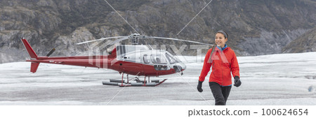 Helicopter pilot woman walking on glacier hiker in Alaska after flying aircraft in the air. Panoramic banner USA travel destination Helicopter pilot woman walking on glacier hiker in Alaska after flying aircraft in the air. Panoramic banner USA travel destination 100624654