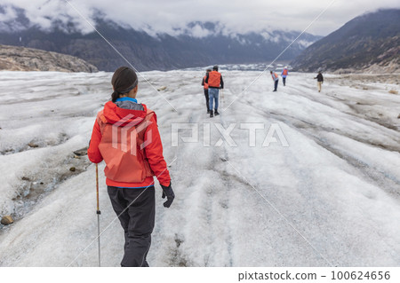 Alaska glacier hiker woman on cruise ship excursion. tourist girl walking with group of hikers on blue ice adventure nature vacation, popular activity in Alaska holidays 100624656