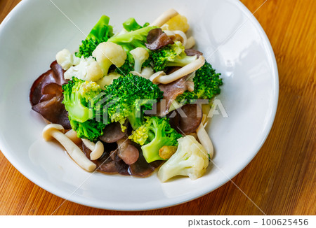Healthy food menu, stir-fried mushrooms, cauliflower, and broccoli, Thai healthy mix vegetable food on a white plate. Close-up image, view from above. 100625456