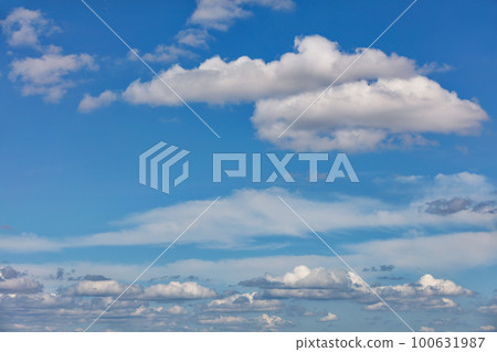 Blue sky background with small white clouds on the horizon. 100631987